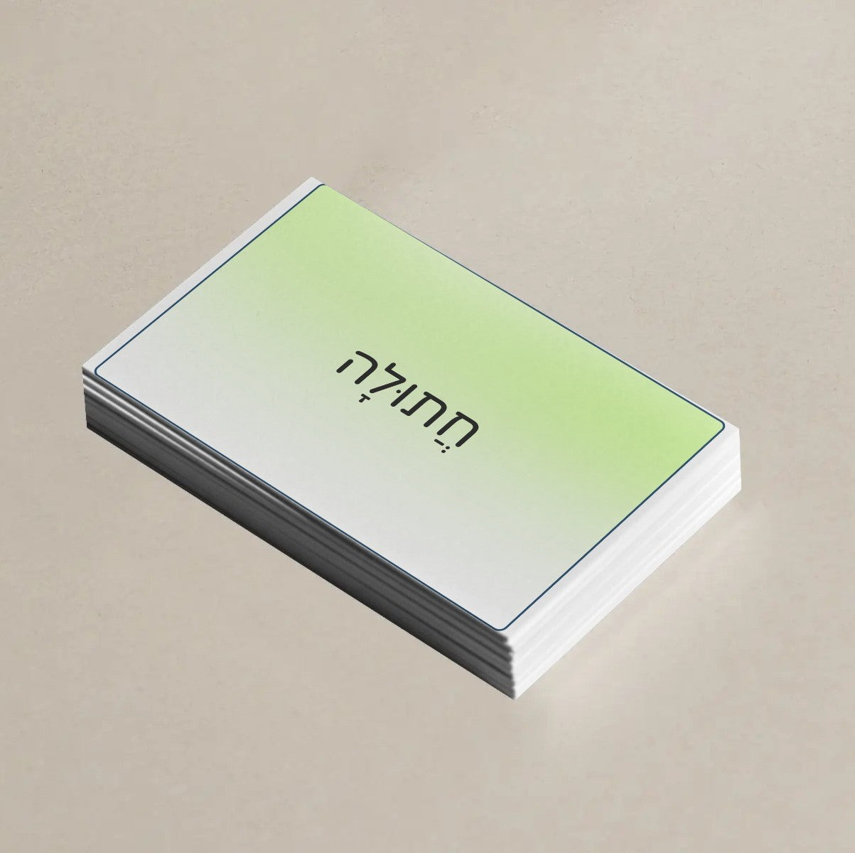 A stack of business cards with a white and light green gradient cover, featuring black Hebrew text, displayed on a neutral beige background.